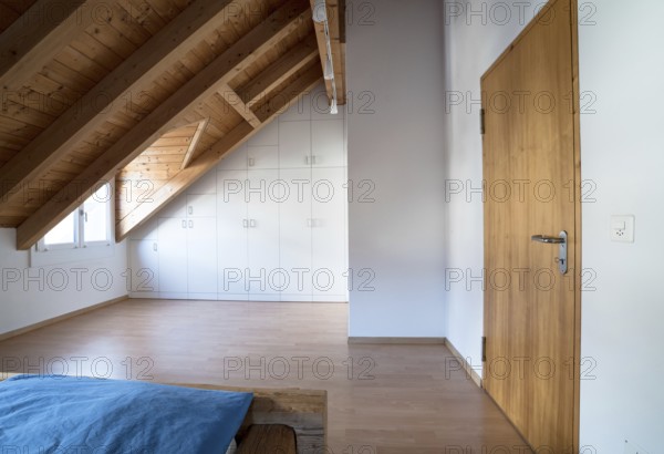 horizontal view of a bright light modern simple master bedroom with wooden parquet floors and