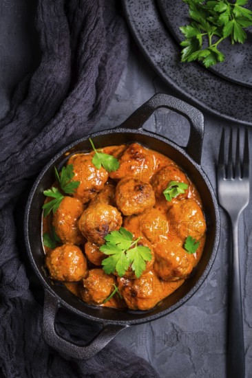 Meatballs with tomato sauce in black pan