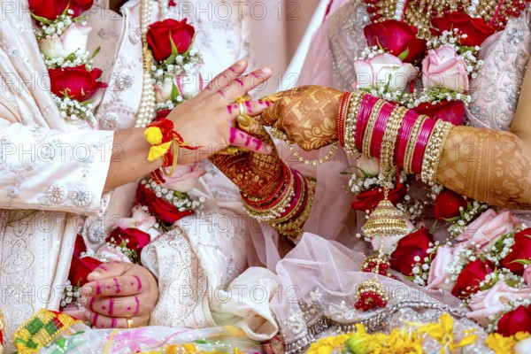Indian bride passing wedding ring on her grooms finger on her wedding ceremony, Mauritius, Africa