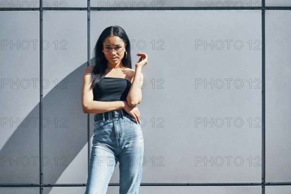 Stylish trendy african american woman posing on street wall urban background with copy space