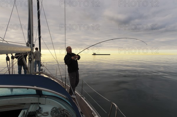Deep-sea angler on the deck of a sailing yacht