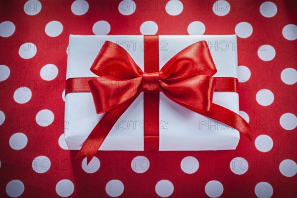 Present box on polka-dot red fabric celebrations concept