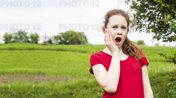 Pretty girl standing park having toothache