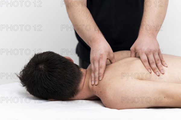 Man being given back massage by physiotherapist