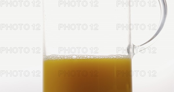 Orange Juice being poured into Glass against White Background