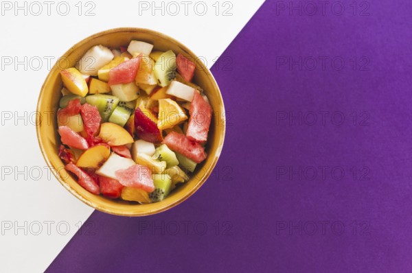 Bowl fruit salad white purple background