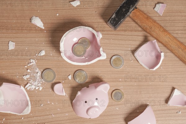 broken Piggy bank smashed into pieces - flat lay with hammer and small or loose change euro coins