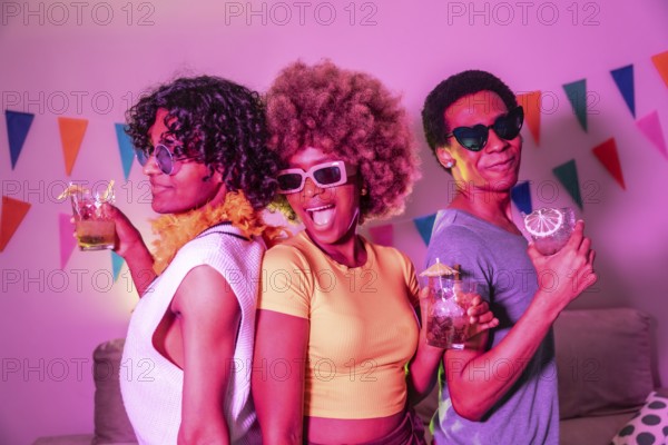 Happy diverse friends laughing partying and drinking alcohol at night with colorful neon light