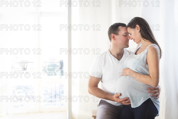 Pregnant woman and young man together indoors