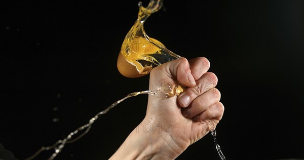 Hand of woman with a Chicken Egg against Black Background