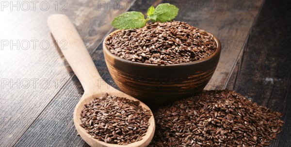 Composition with bowl of flax seeds on wooden table