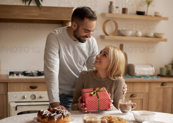 Man surprising woman with present