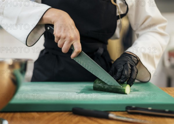 Front view female chef slicing cucumber