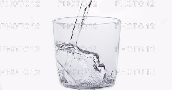 Water being poured into Glass against White Background