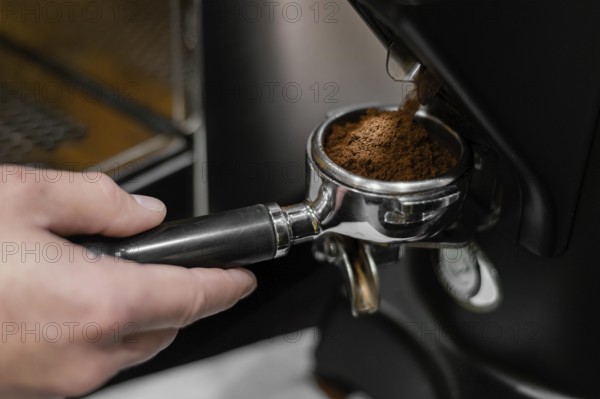 Close up male barista using professional coffee machine. Beautiful photo