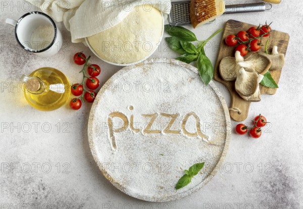 Top view pizza dough with mushrooms tomatoes word written flour