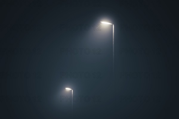 Street lights in the misty evening glowing in the dark by midnight