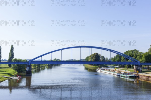 Barge loaded with bulk cargo lying in harbour on the river Weser with railway bridge (Hoya), Lower
