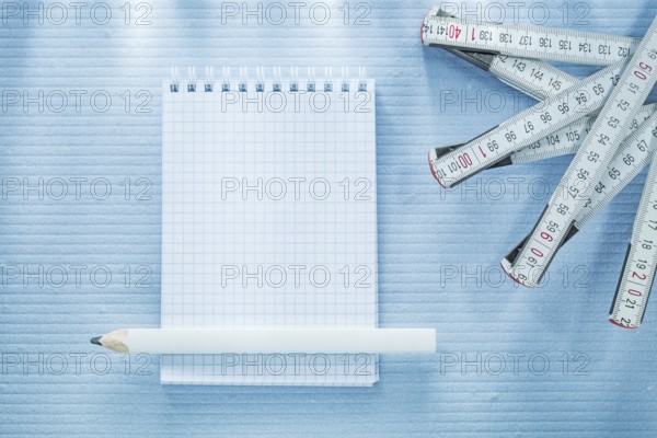 Checked notebook pencil measuring tape construction concept