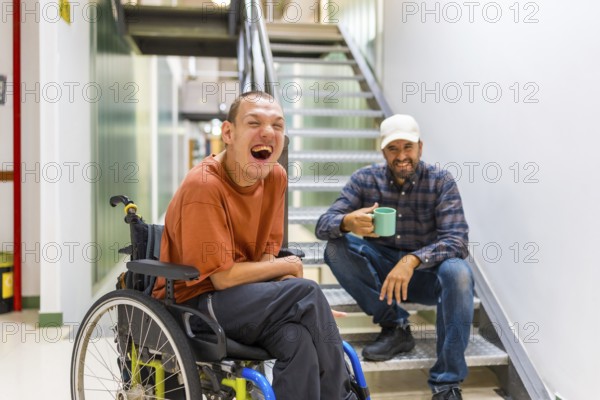 Man with cerebral palsy having fun with teamwork in coworking during a coffee break indoors