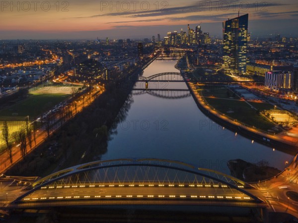 The lights of the European Central Bank (ECB) and the Frankfurt banking skyline glow in the evening
