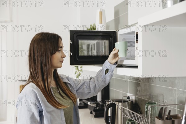 Casual girl using microwave heat cup. Resolution and high quality beautiful photo
