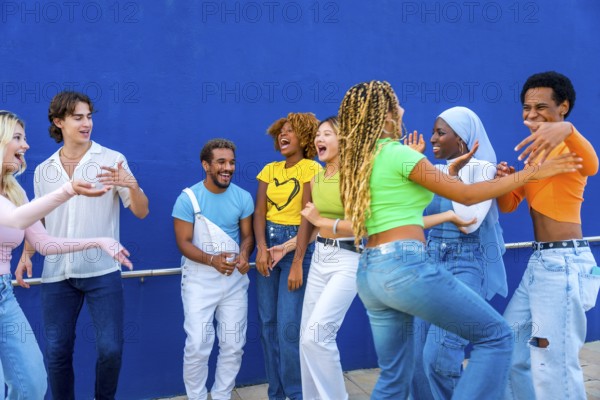 Group of young people dancing together outdoors in a multicultural party