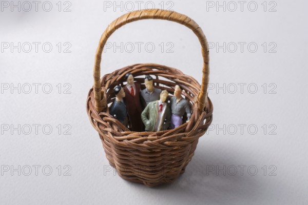 Tiny figurine of group of men miniature model in basket