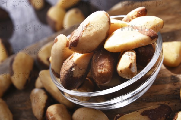 Composition with a bowl of shelled brazil nuts. Delicacies