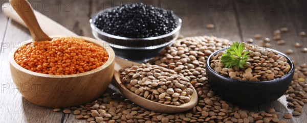 Composition with three sorts of lentils on wooden table