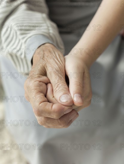 Close up granddaughter holding grandmothers hand. Beautiful photo