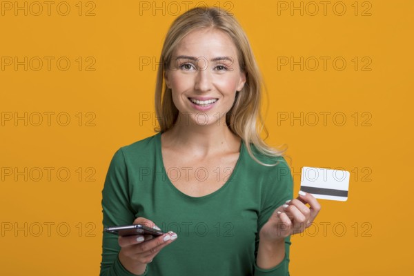 Smiley woman holding smartphone credit card