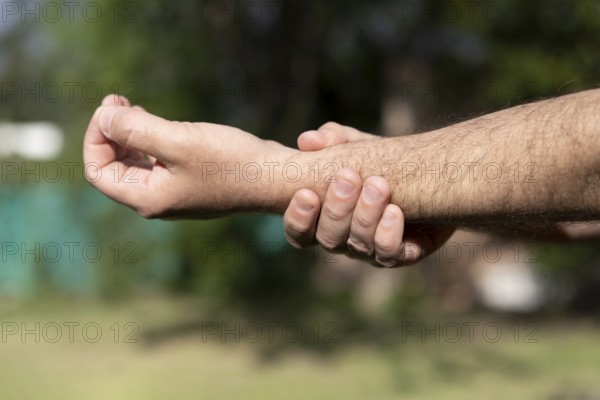 Close-up of man massaging his wrist