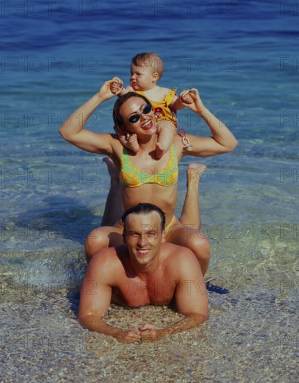 Family with baby on the beach/sea