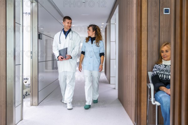 Medical colleagues walking and talking along the corridor of an hospital to the waiting room