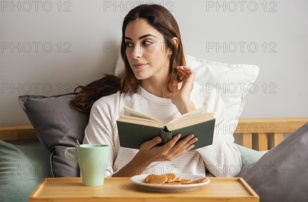 Front view woman reading having breakfast home