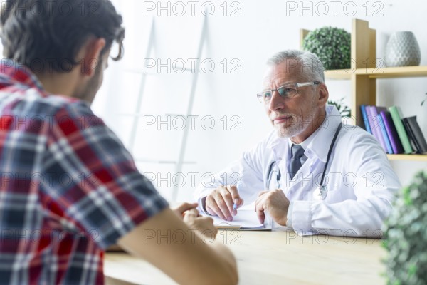 Senior doctor listening patient closely