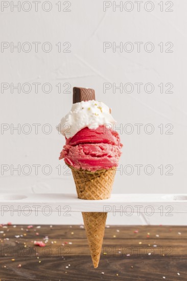 Red frozen ice scoop with with whipped cream chocolate cone
