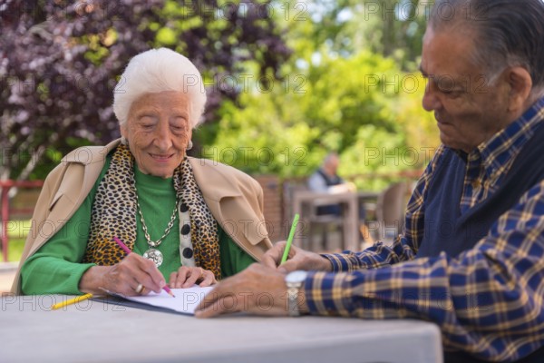 Two elderly people painting in the garden of a nursing home or retirement home
