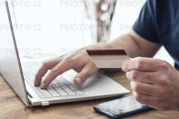 person using credit card and laptop computer for online shopping and payment, e-commerce concept