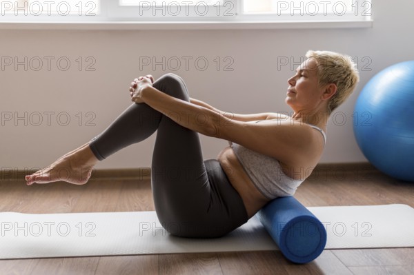 Senior woman with short hair using yoga mat