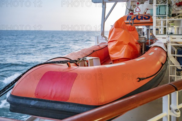 Orange AIDA Bella Cruise Ship lifeboat attached to the ship during sunset