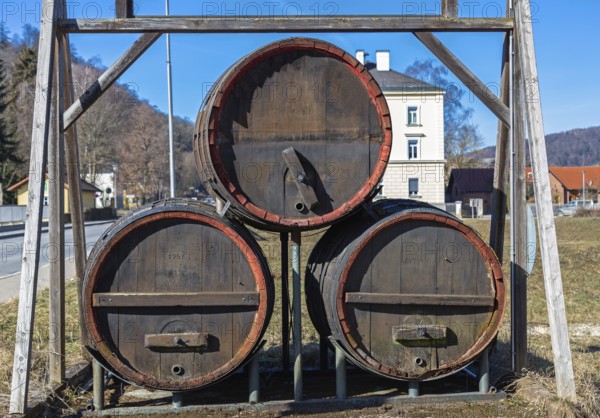 Three large old beer barrels on a road in Bavaria