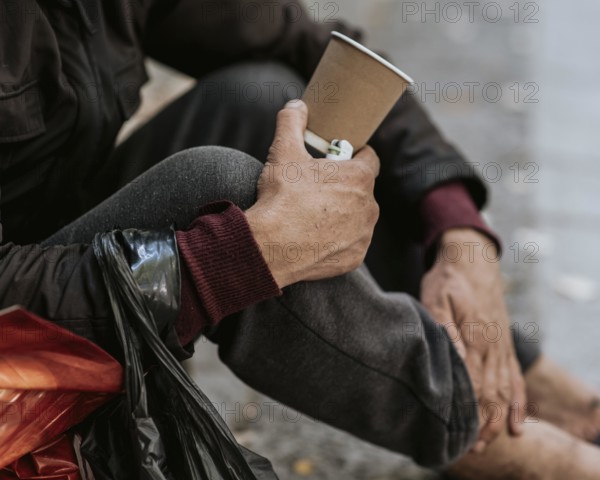 Side view homeless man holding cup