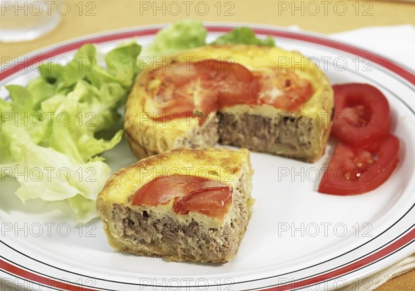 Tuna quiche with tomato and salad in plate