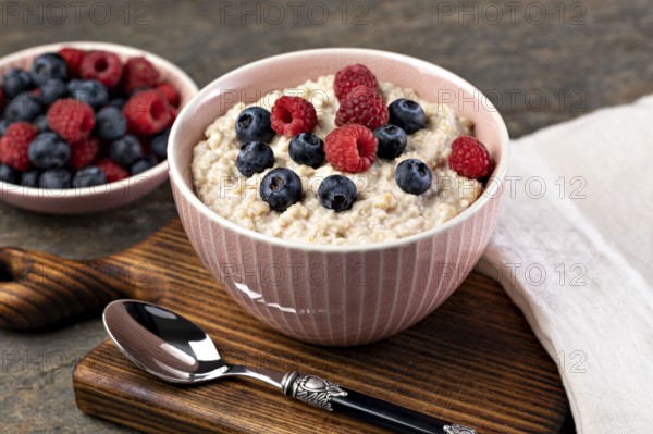 prepared oatmeal with berries on a wooden table