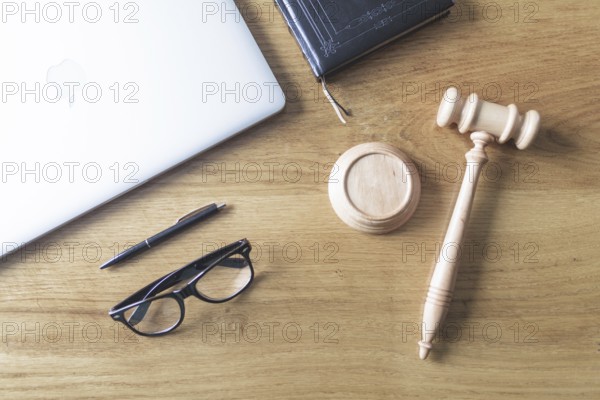 High angle view of laptop spectacles gavel and pen on wooden background on wooden desk