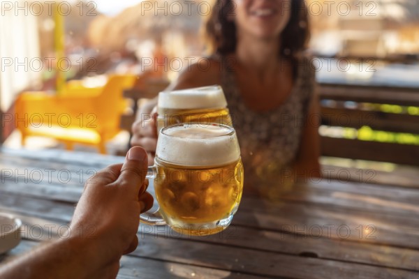 Toast of a couple on the beach in summer drinking a few beers in a celebration of friendship