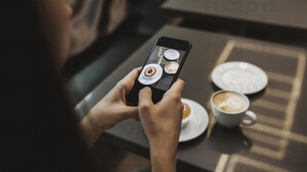 Young woman taking picture her coffee