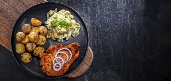Chicken cutlet coated with breadcrumbs served with potatoes and cabbage